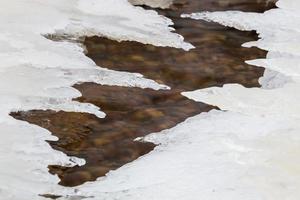 costa del mar báltico con guijarros y hielo al atardecer foto