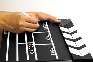 The hand is holding clapper board or movie slate black color and marker pen. Cinema industry concept. photo