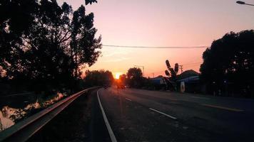 amanecer de la mañana en la carretera de Indonesia. hermoso color del amanecer y el cielo foto