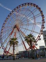 Ferris wheel against the sky. Amusement park on the sea. Rest zone. Ferris wheel.  Family holiday