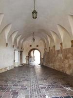 The Upper Gate that leads to the tiered arcaded inner courtyard of the Wawel Royal Castle in Krakow, Poland, Europe. Polished old stone pavement. photo