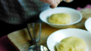 misture os ingredientes do bolo com a batedeira. o bebê está sentado em uma cadeira e se divertindo video