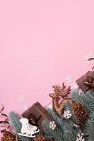 Pine trees branches with Cristmas New Year decoration top view, flat lay on pink background with copy space. Blank greeting card photo