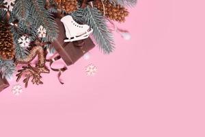 Pine trees branches with Cristmas New Year decoration top view, flat lay on pink background with copy space. Blank greeting card photo