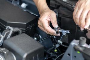 A man hold Xenon car headlights and and inserted into the headlight to replace the broken bulb in engine room , Replacing the headlight bulbs of the car itself service concept photo