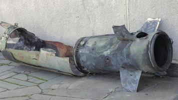 un fragmento de metal de un cohete militar yace en el suelo después del bombardeo de una casa civil. fuego de cohetes sobre la ciudad y el horror de la guerra. guerra de ucrania el proyectil está en el suelo. video