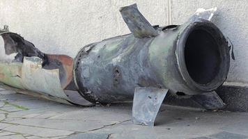 un fragmento de metal de un cohete militar yace en el suelo después del bombardeo de una casa civil. fuego de cohetes sobre la ciudad y el horror de la guerra. guerra de ucrania el proyectil está en el suelo. video