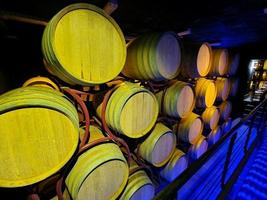 Bodega antigua con barriles de roble apilados iluminados en una bodega foto