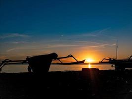 silhouette of objects on the beach with sunrise photo