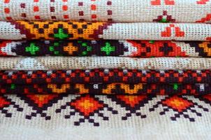 Stack of traditional Ukrainian folk art knitted embroidery patterns on textile fabric photo