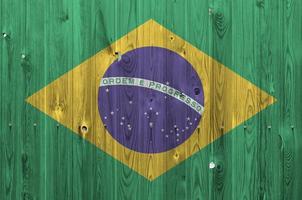 Brazil flag depicted in bright paint colors on old wooden wall. Textured banner on rough background photo