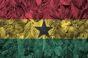 bandera de ghana representada en muchas hojas de palmeras monstera. telón de fondo de moda foto