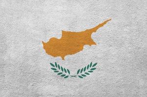 Cyprus flag depicted in bright paint colors on old relief plastering wall. Textured banner on rough background photo