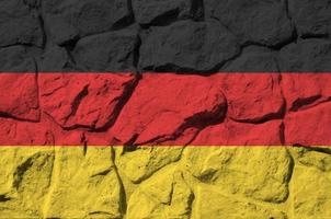 bandera de alemania representada en colores de pintura en el primer plano de la pared de piedra antigua. banner texturizado sobre fondo de pared de roca foto