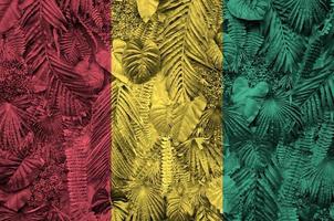 Guinea flag depicted on many leafs of monstera palm trees. Trendy fashionable backdrop photo