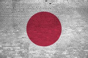 Japan flag depicted in paint colors on old brick wall. Textured banner on big brick wall masonry background photo