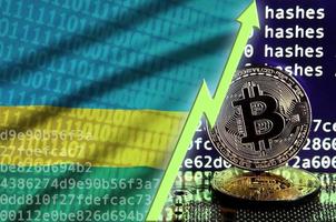 Rwanda flag and rising green arrow on bitcoin mining screen and two physical golden bitcoins photo