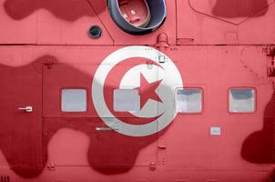 Tunisia flag depicted on side part of military armored helicopter closeup. Army forces aircraft conceptual background photo