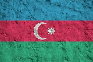 Azerbaijan flag depicted in bright paint colors on old relief plastering wall. Textured banner on rough background photo