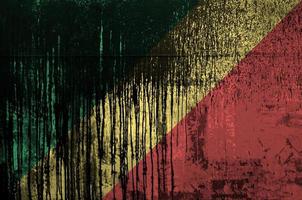 Congo flag depicted in paint colors on old and dirty oil barrel wall closeup. Textured banner on rough background photo