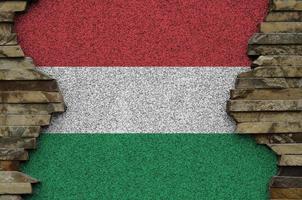 Hungary flag depicted in paint colors on old stone wall closeup. Textured banner on rock wall background photo