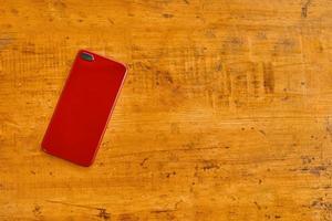 Flat lay of mobile phone on wooden table. photo