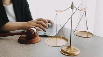 Justice and law concept.Male judge in a courtroom with the gavel, working with, computer and docking keyboard, eyeglasses, on table in morning light video