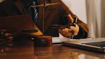 Justice and law concept.Male judge in a courtroom with the gavel, working with, computer and docking keyboard, eyeglasses, on table in morning light video