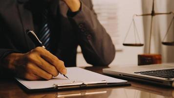 Justice and law concept.Male judge in a courtroom with the gavel, working with, computer and docking keyboard, eyeglasses, on table in morning light video