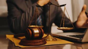 Justice and law concept.Male judge in a courtroom with the gavel, working with, computer and docking keyboard, eyeglasses, on table in morning light video