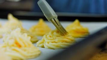 el chef hace galletas de patata con una bolsa de comida. Receta canónica de galletas de patata con brie, parmesano y nata. fotografía macro video