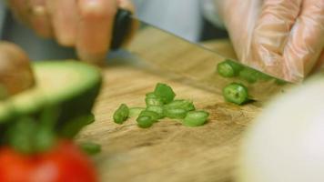 Cortar un pimiento verde y picante en rodajas pequeñas. fotografía macro video