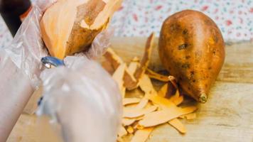 Der Koch schneidet die Süßkartoffeln in Scheiben. romantische Atmosphäre im Hintergrund video