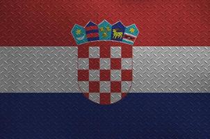 Croatia flag depicted in paint colors on old brushed metal plate or wall closeup. Textured banner on rough background photo