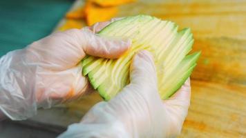 io hold nel mio mani un avocado tagliare in dritto forme. macro tiro video