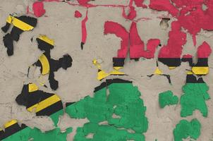 Vanuatu flag depicted in paint colors on old obsolete messy concrete wall closeup. Textured banner on rough background photo