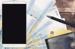Billetes de 1000 florines húngaros y smartphone con monedero y tarjeta de crédito. pagos electrónicos o concepto de comercio electrónico. compras y negocios en línea con dispositivos portátiles foto