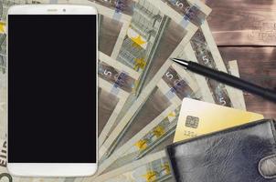 5 euro bills and smartphone with purse and credit card. E-payments or e-commerce concept. Online shopping and business with portable devices photo