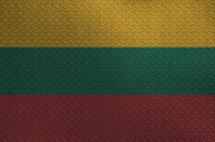 Lithuania flag depicted in paint colors on old brushed metal plate or wall closeup. Textured banner on rough background photo