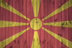 bandera de macedonia representada en colores de pintura brillante en la pared de madera vieja. banner texturizado sobre fondo áspero foto