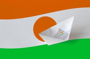 Niger flag depicted on paper origami ship closeup. Handmade arts concept photo