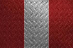 Peru flag depicted in paint colors on old brushed metal plate or wall closeup. Textured banner on rough background photo