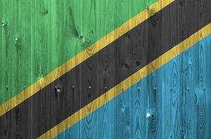 Tanzania flag depicted in bright paint colors on old wooden wall. Textured banner on rough background photo