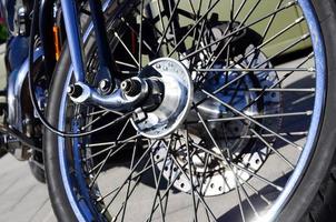 Fragment of chromed shiny wheel of old classic motorbike photo