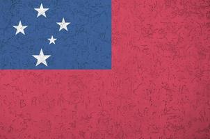 Samoa flag depicted in bright paint colors on old relief plastering wall. Textured banner on rough background photo