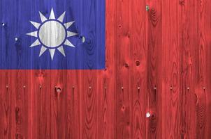 Taiwan flag depicted in bright paint colors on old wooden wall. Textured banner on rough background photo