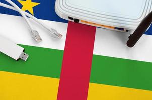 bandera de la república centroafricana representada en la mesa con cable de internet rj45, adaptador wifi usb inalámbrico y enrutador. concepto de conexión a internet foto