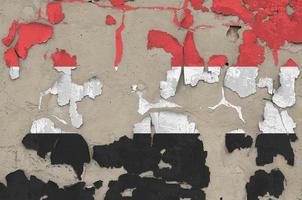 Yemen flag depicted in paint colors on old obsolete messy concrete wall closeup. Textured banner on rough background photo