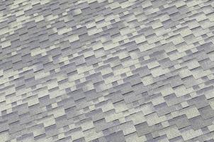 Background mosaic texture of flat roof tiles with bituminous coating photo