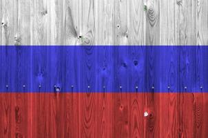 Russia flag depicted in bright paint colors on old wooden wall. Textured banner on rough background photo